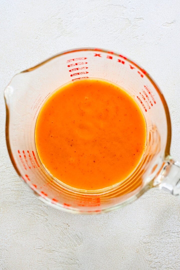 Overhead view of peach puree in a measuring cup.