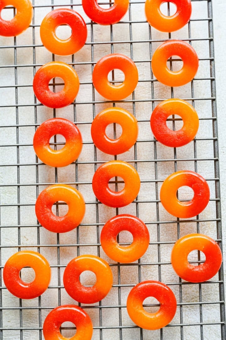 Overhead view of peach rings on a cooling rack.