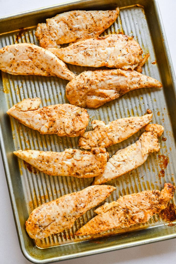 Overhead view of chicken tenders on a sheet pan.