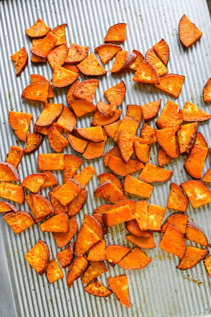 Overhead view of sweet potatoes on a sheet pan.