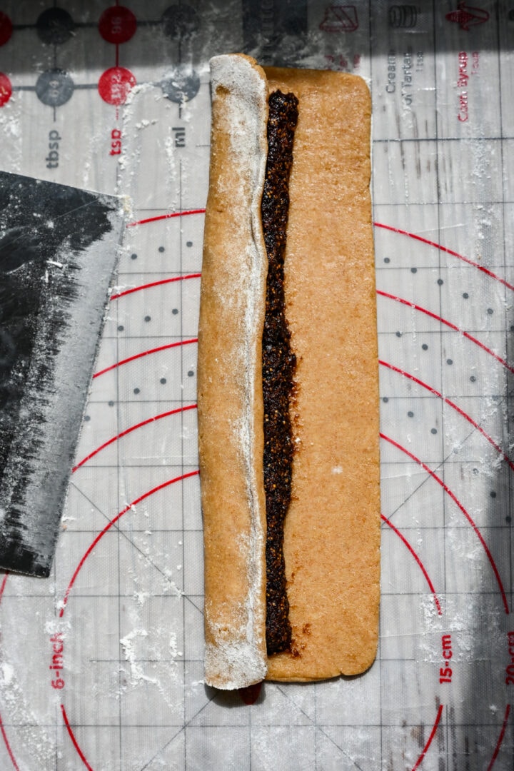 Forming the cookie by flipping dough over the filling.