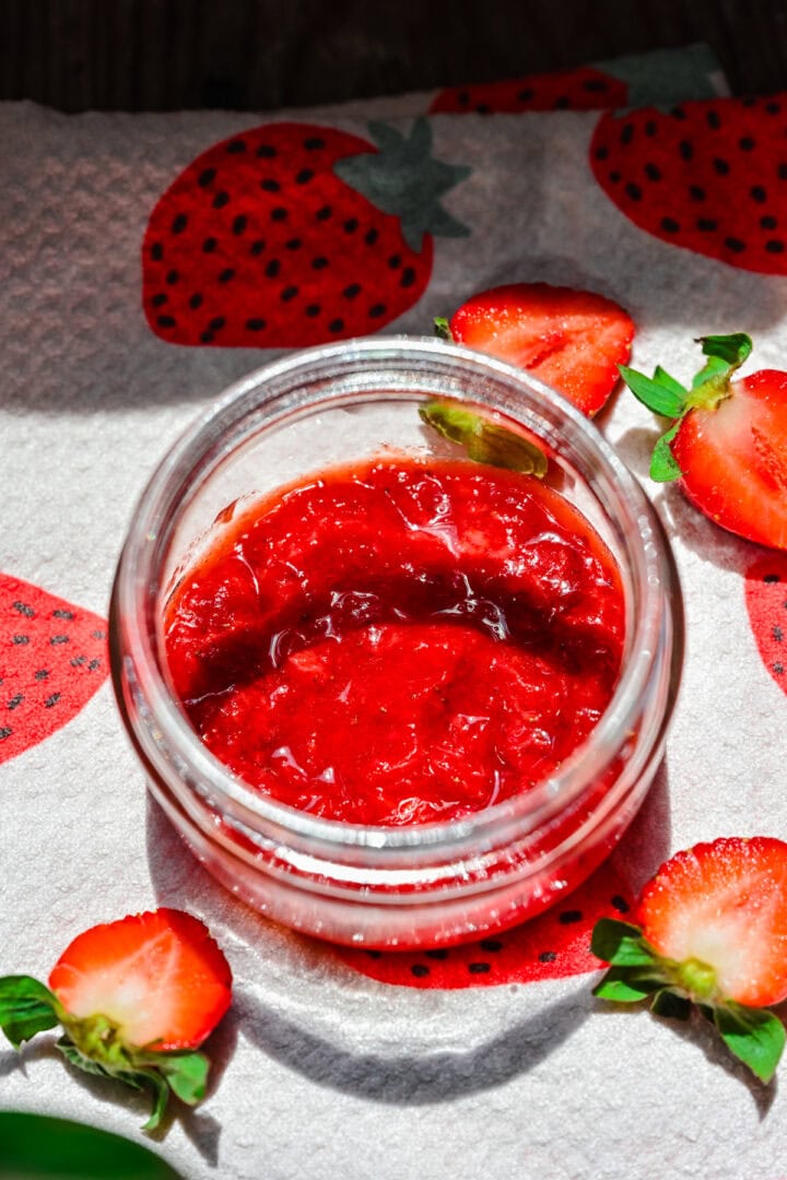 Overhead view of jar with strawberry on the bottom.