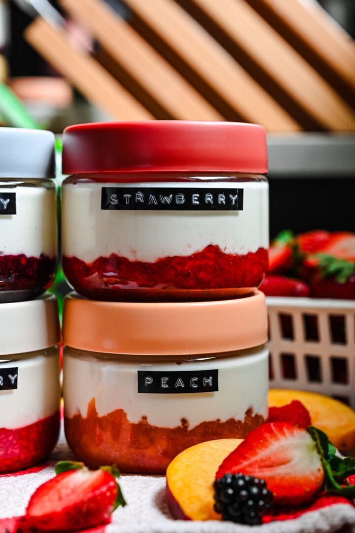 Front view of strawberry and peach yogurt in jars.