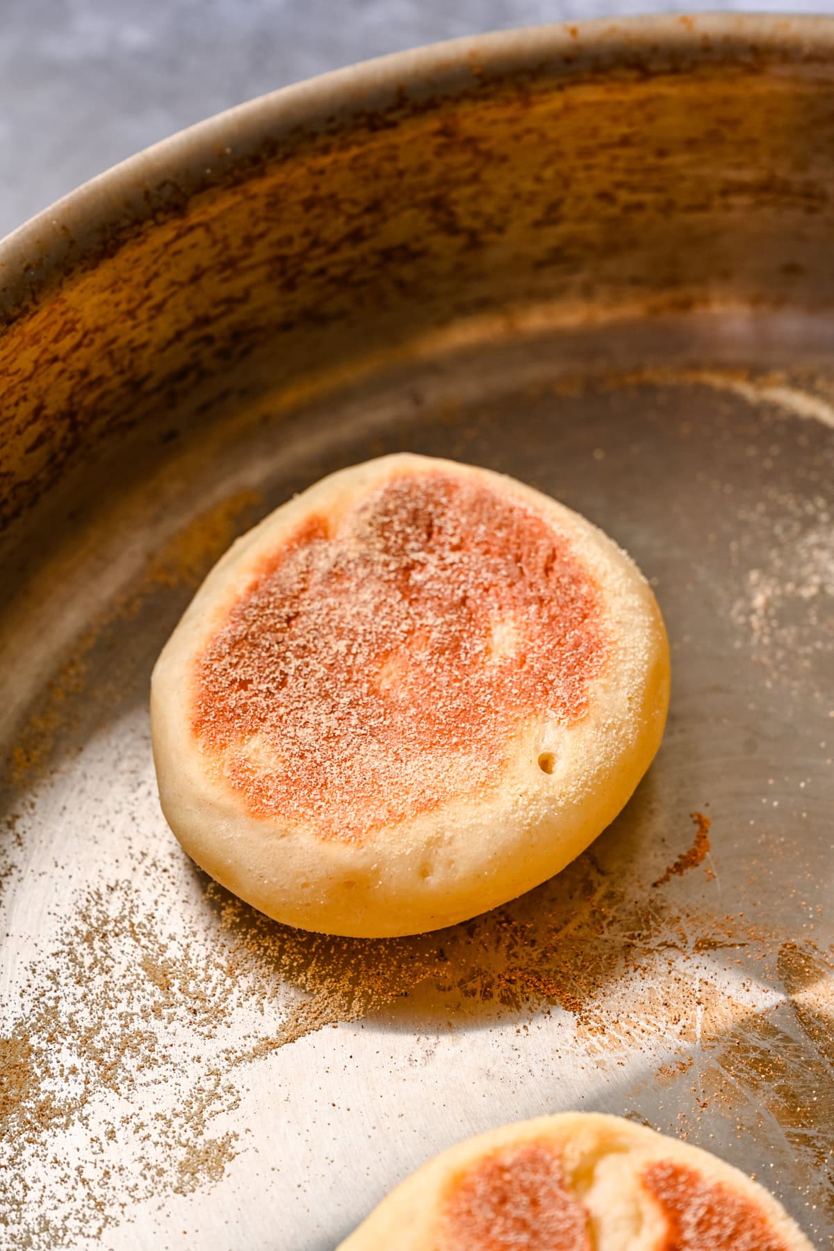 English muffin cooking in a pan.
