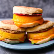 Front view of 3 egg sandwiches on a blue plate.