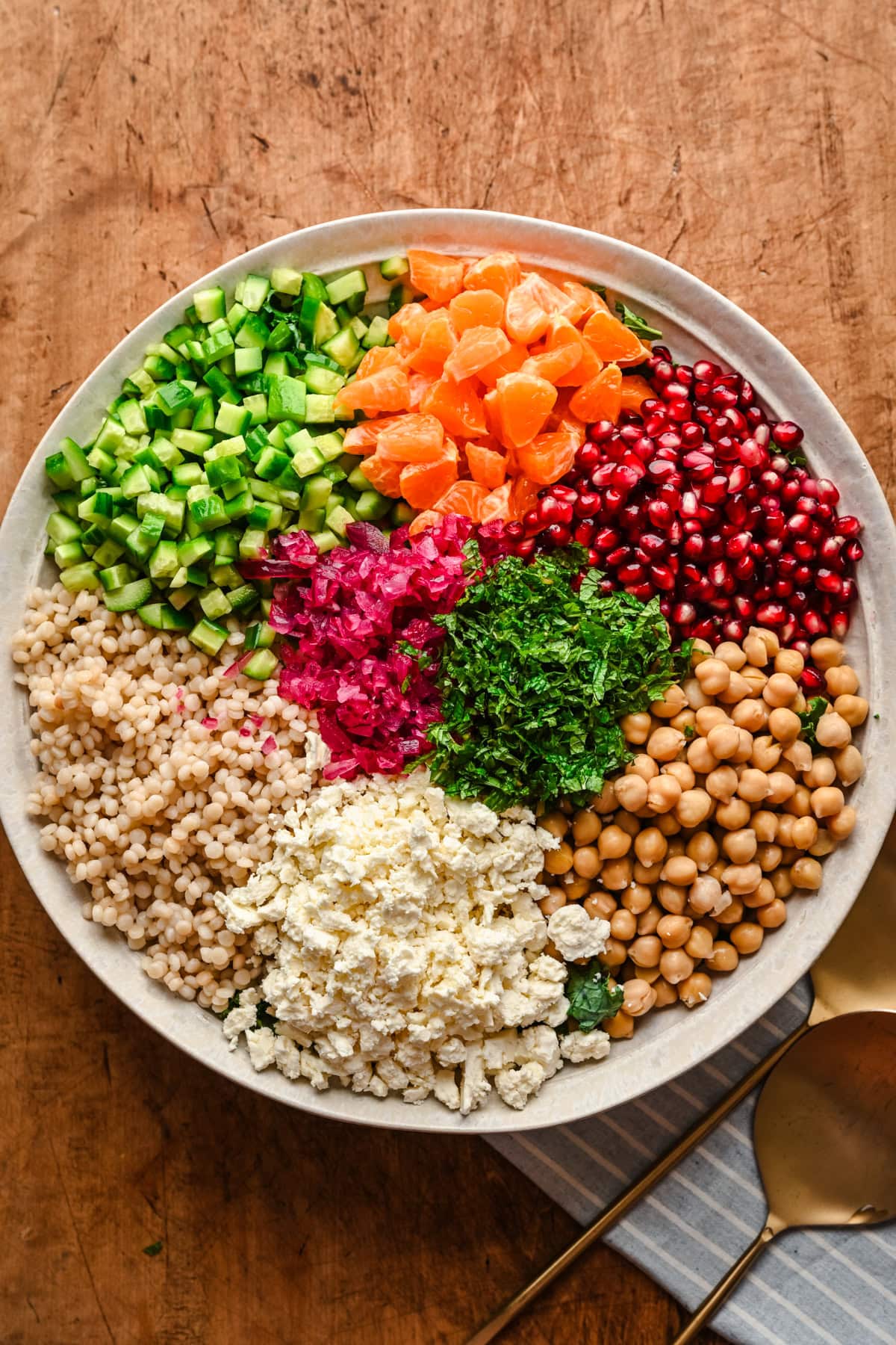 overhead view of kale couscous salad ingredients in a large bowl. 