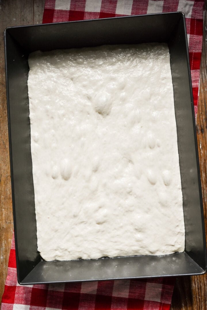Overhead view of pizza dough in pan.