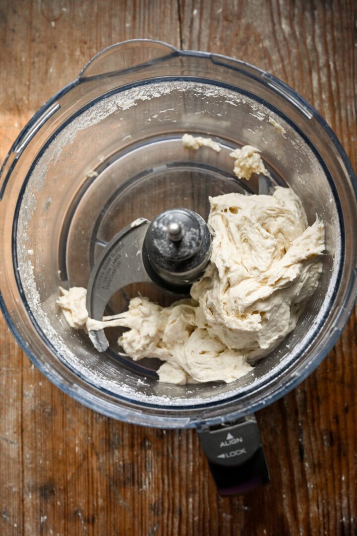 Overhead view of dough in a food processor.
