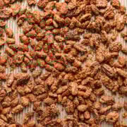 Crunchy cinnamon roasted almonds on a rustic wooden surface.