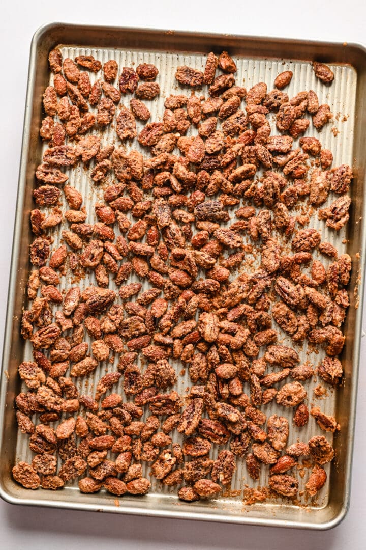 Overhead view of finished candied nuts on a sheet pan.