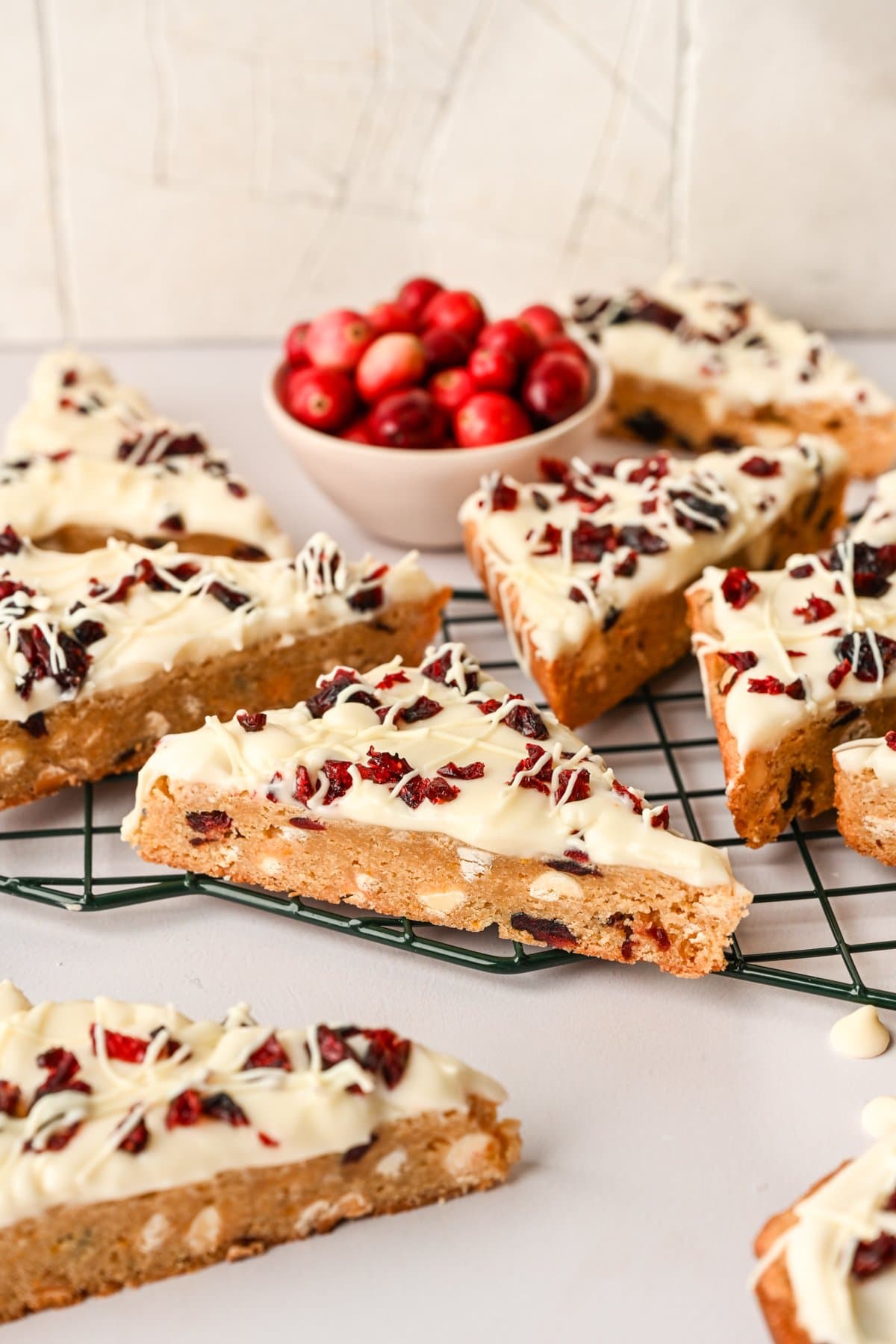 Side view of cranberry bliss bars on baking rack.