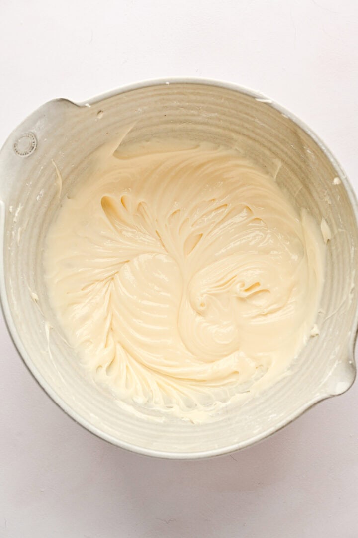 Overhead view of cream cheese frosting in mixing bowl.