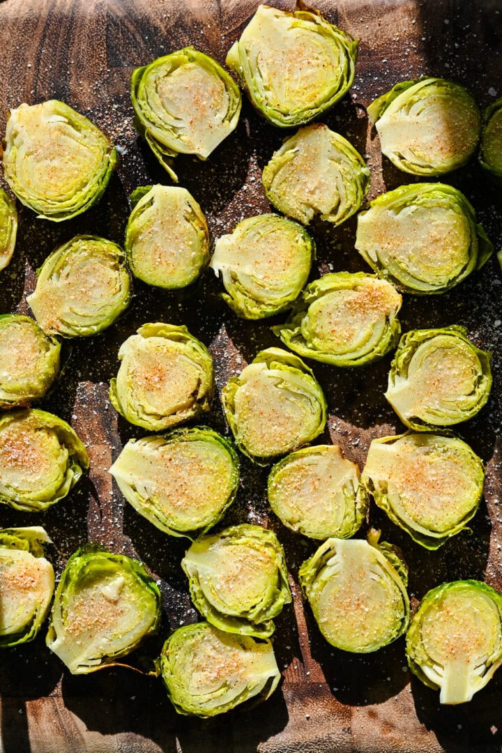 Overhead view of brussels sprouts after seasoning the top of them.
