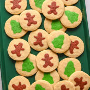 Gingerbread men and christmas tree cookies on a sheet pan.