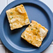 Overhead view of biscuit cut in half with butter.