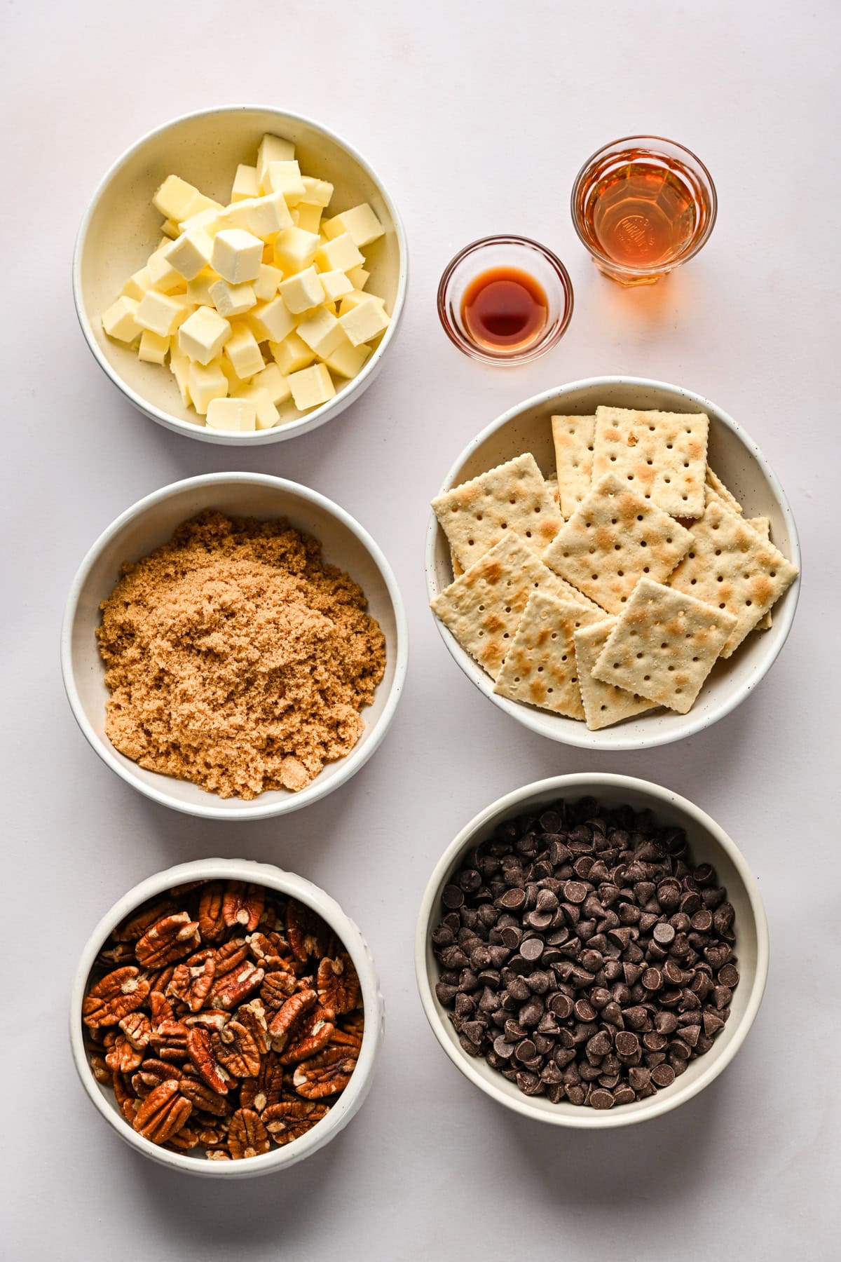 Overhead view of ingredients for bourbon pecan christmas crack in bowls.