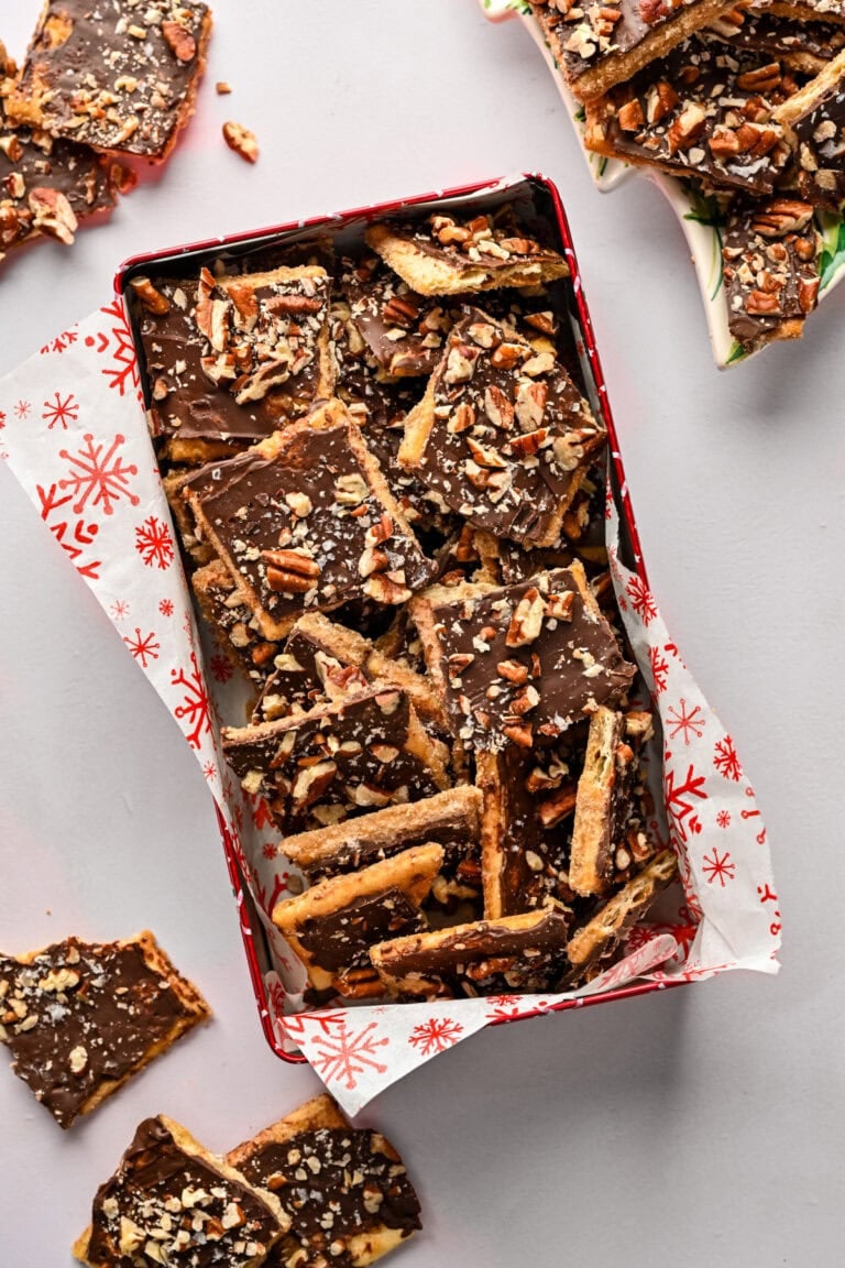 Chocolate caramel almond crunch bars in a festive tin, perfect holiday treat.