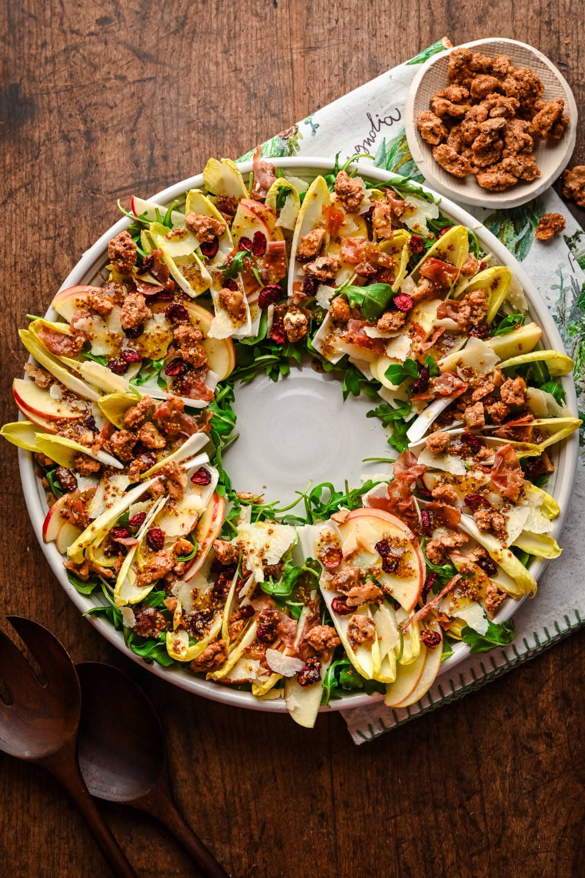 Overhead view of Christmas wreath salad with endive and candied walnuts on platter. 