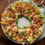 Overhead view of Christmas wreath salad with endive and candied walnuts on platter.