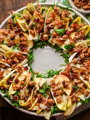 Overhead view of Christmas wreath salad with endive and candied walnuts on platter.