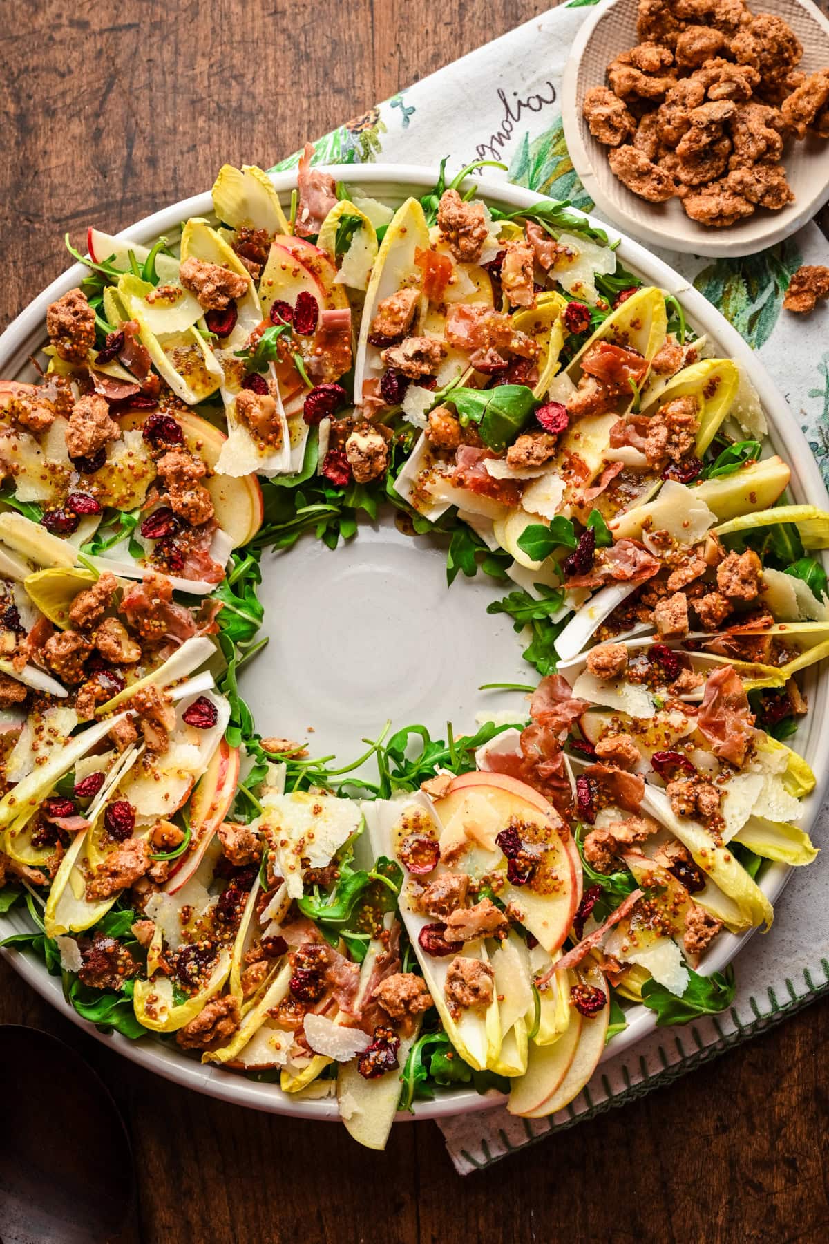 Overhead view of Christmas wreath salad with endive and candied walnuts on platter.