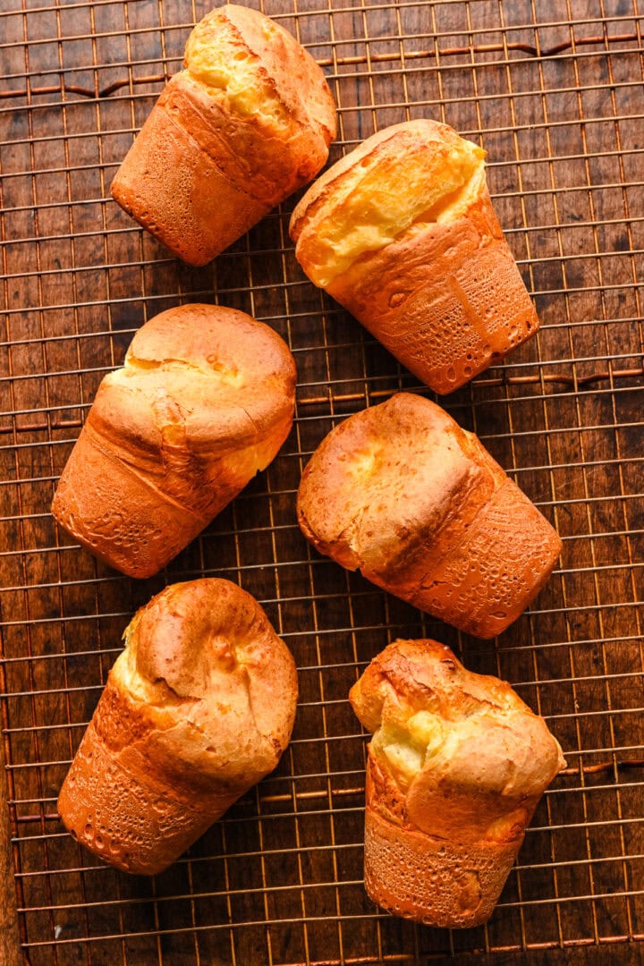 6 popovers resting on a cooling rack.