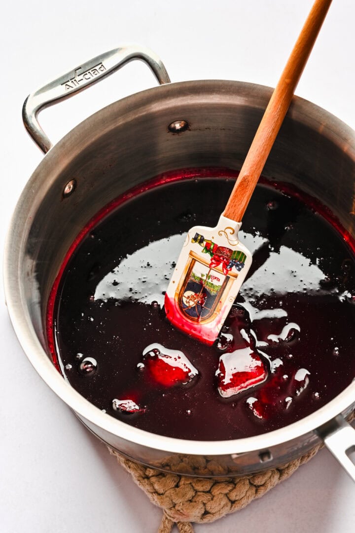 Reduced pomegranate juice and cranberry juice in a pot seen from overhead.