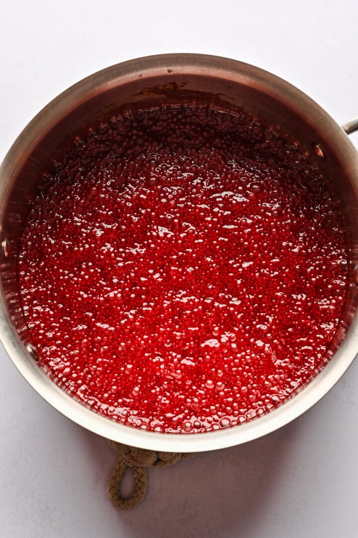 Pomegranate caramel liquid boiling in a pan.