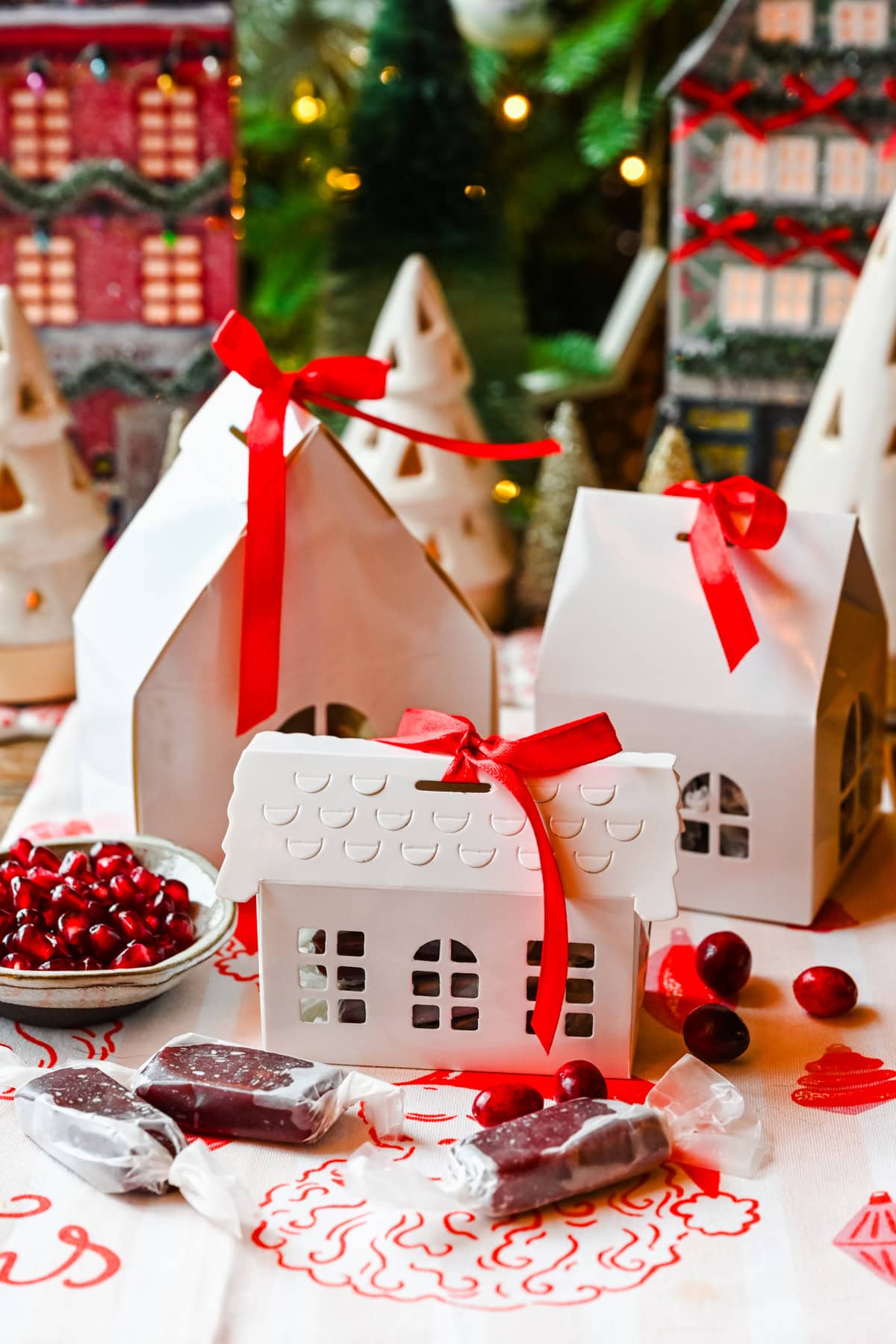 Pomegranate caramels in gift boxes surrounded by christmas decor.
