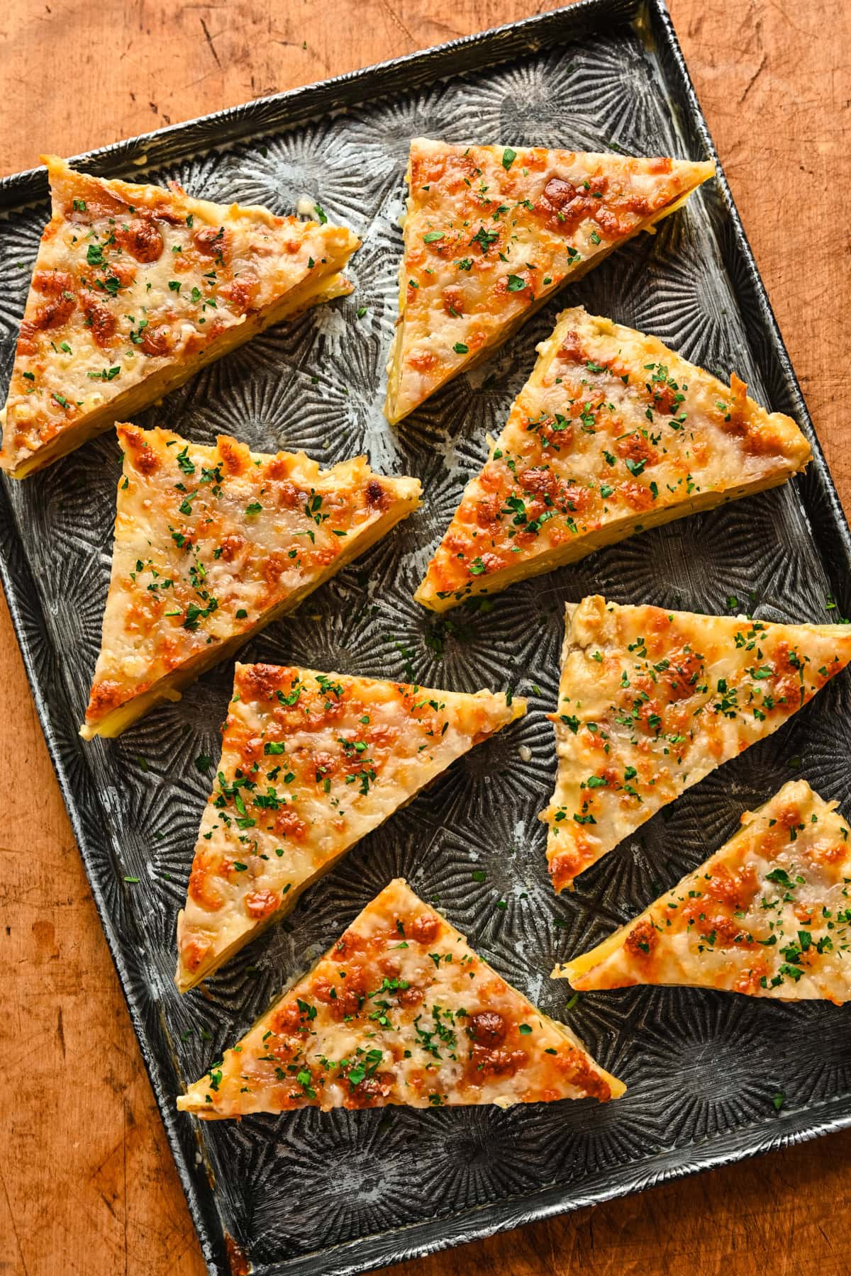 Triangles of potatoes dauphinoise on a platter.