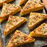 Creamy Baked Lasagna Slices with cheese and herbs on metal tray.