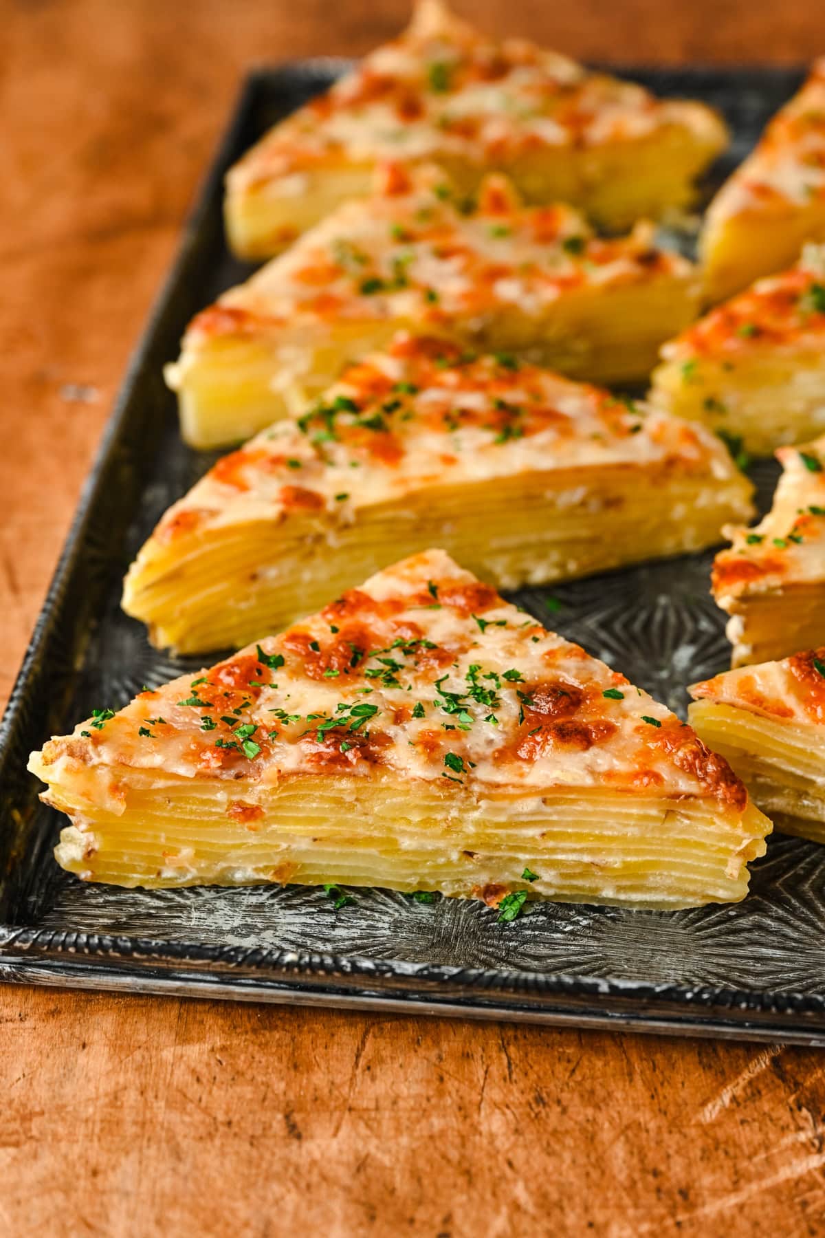 Triangles of potatoes dauphinoise on a platter.