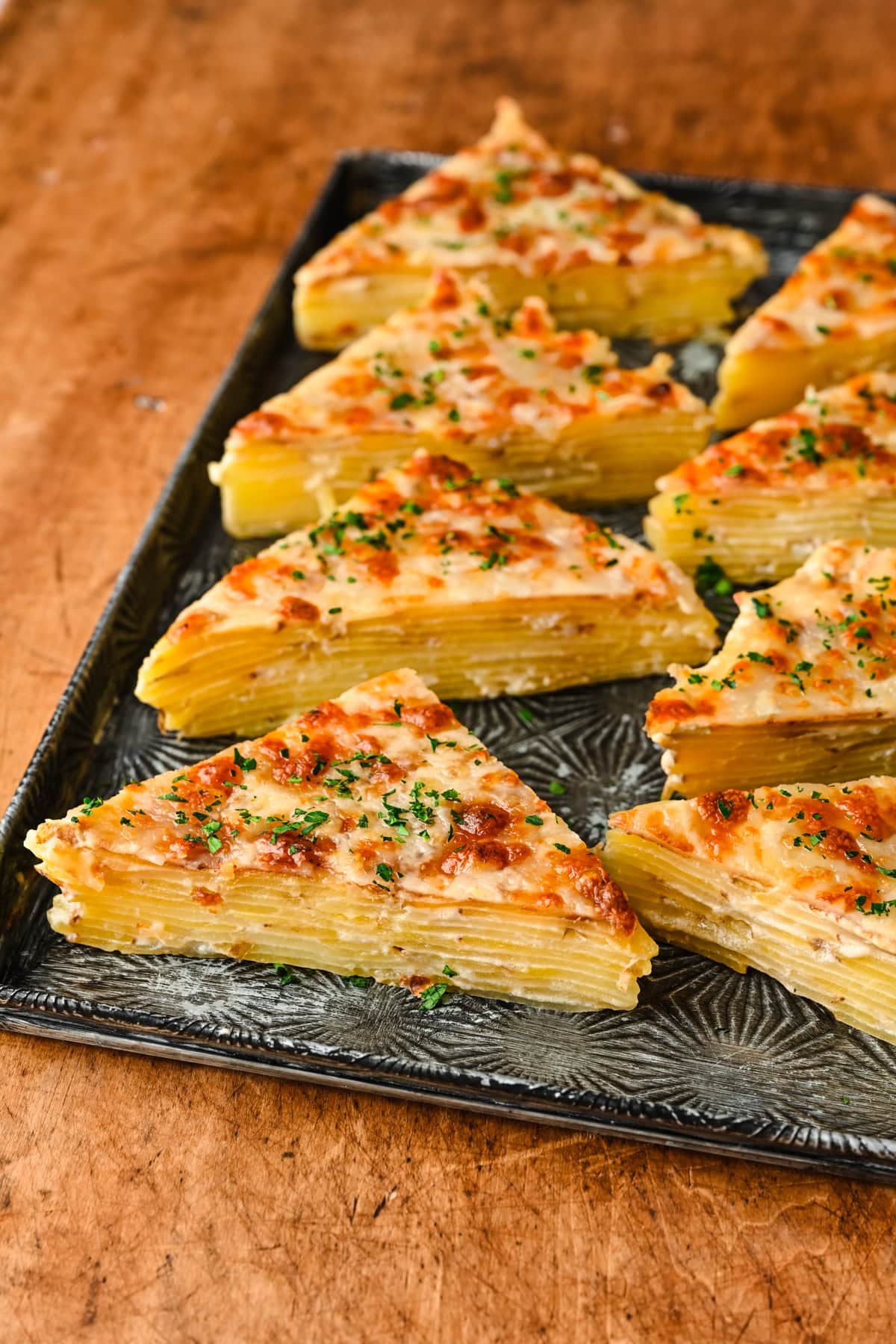 Triangles of potatoes dauphinoise on a platter.