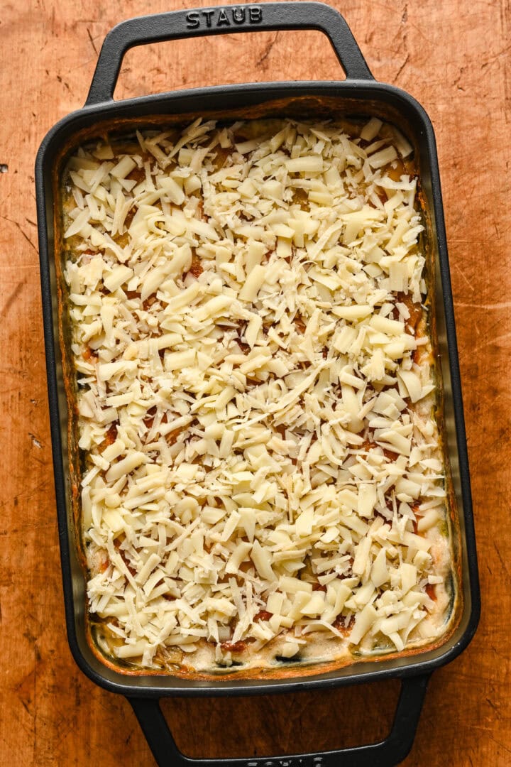Adding cheese on top of potatoes.