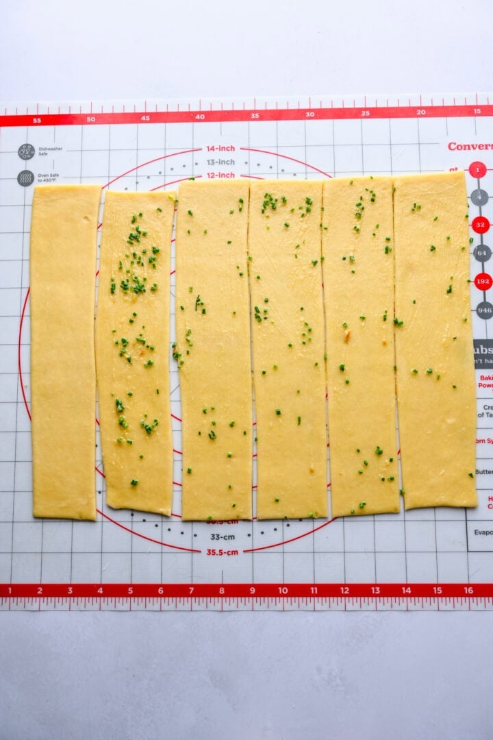 garlic herb butter spread on strips of dough.