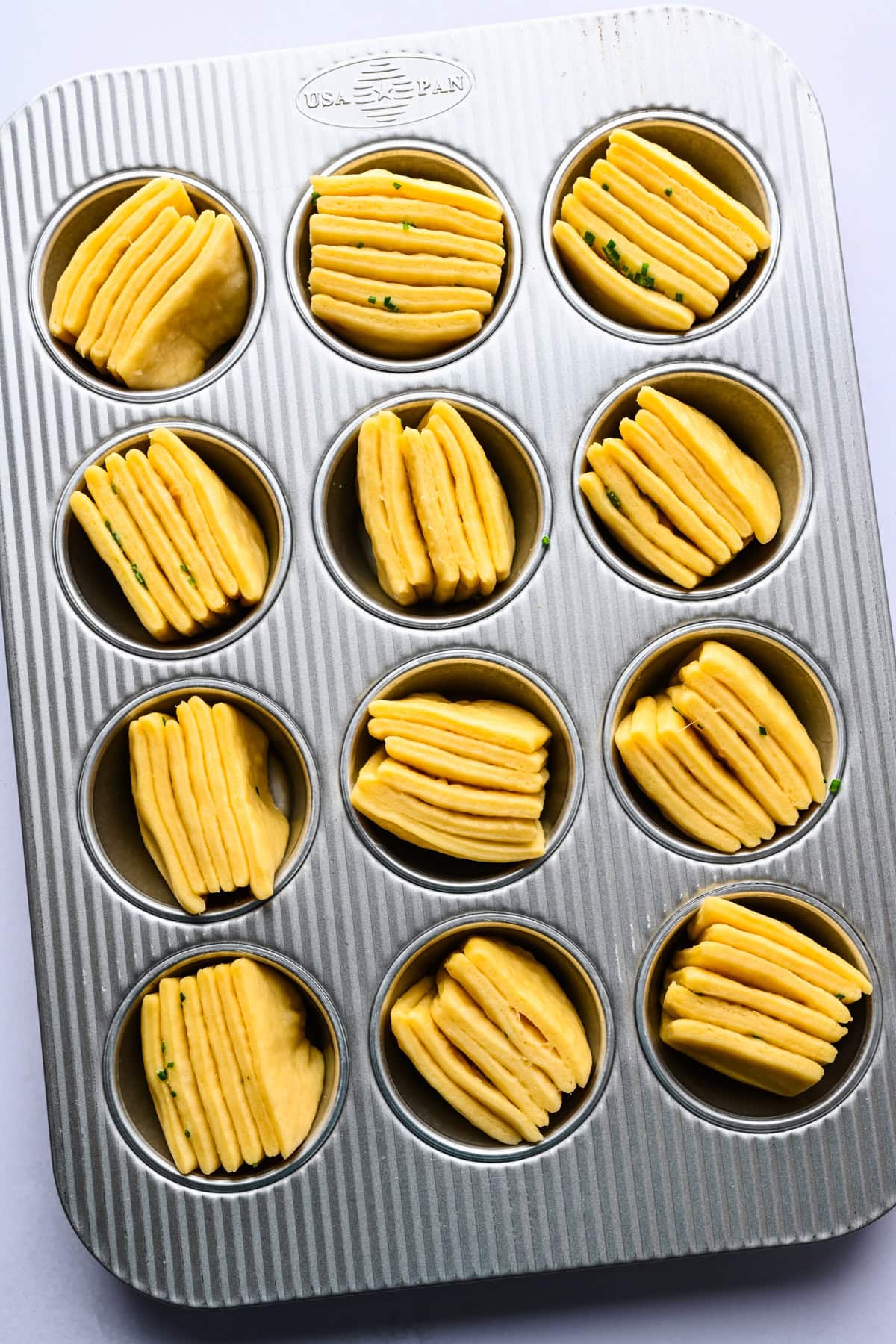 Fan rolls in muffin tin before baking.