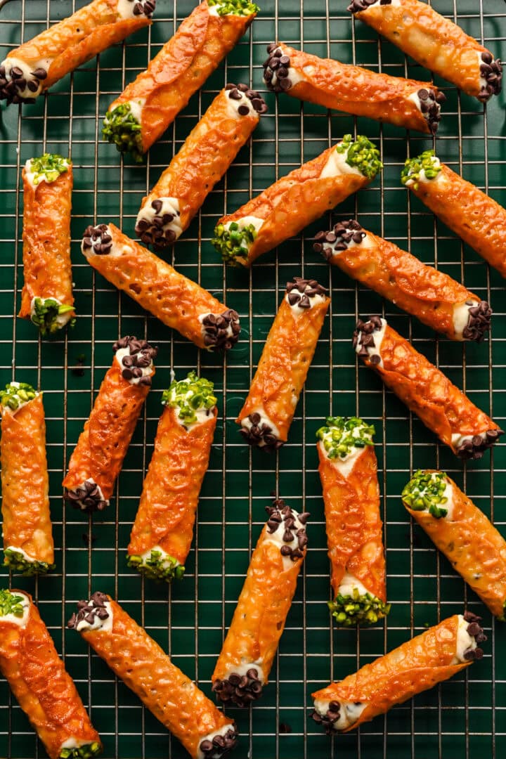 Overhead view of cannoli made with a florentine cookie, garnished with mini chocolate chips and pistachios.