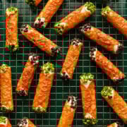 Overhead view of cannoli made with a florentine cookie, garnished with mini chocolate chips and pistachios.