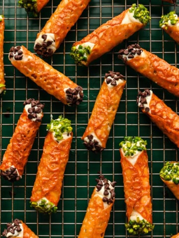 Overhead view of cannoli made with a florentine cookie, garnished with mini chocolate chips and pistachios.