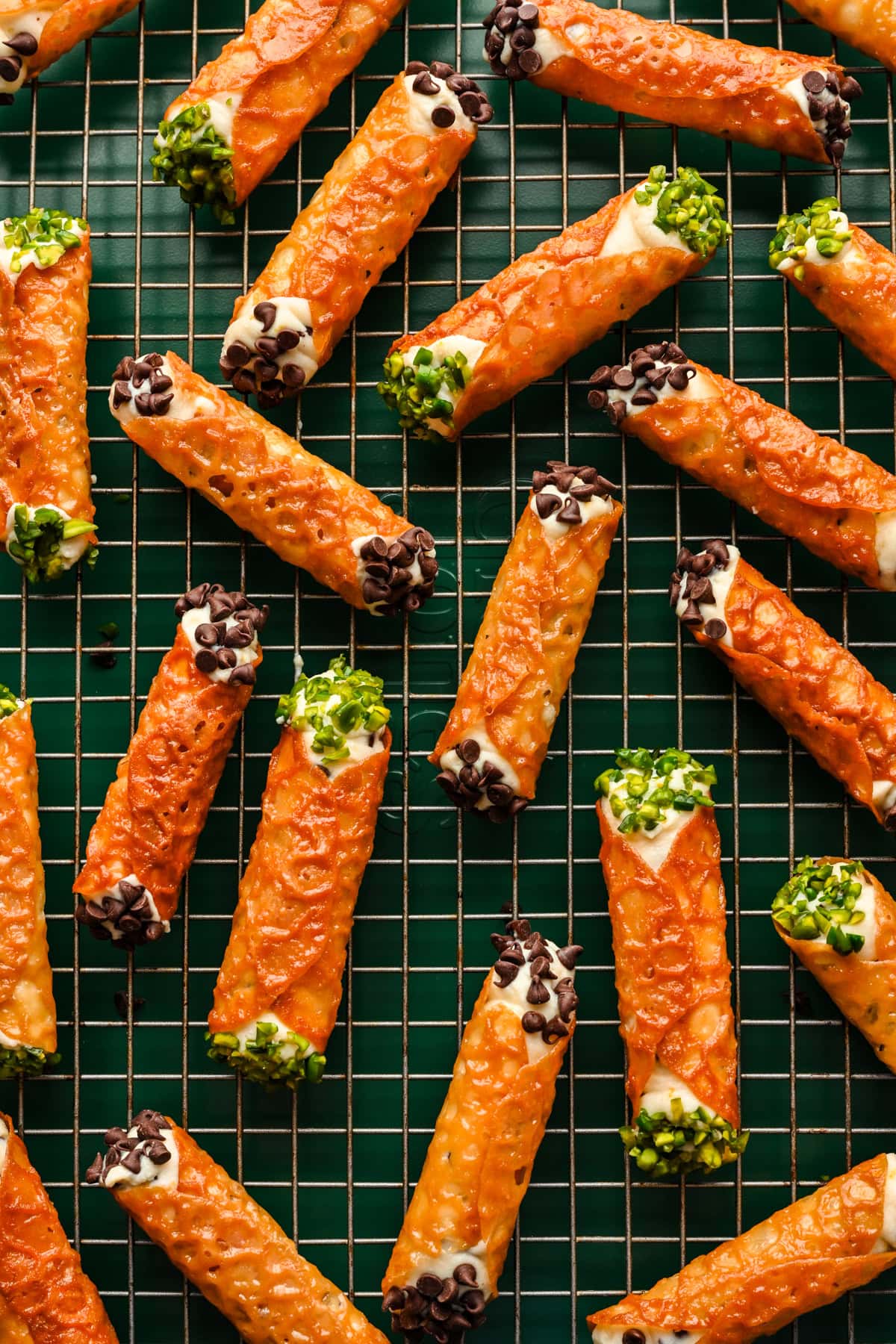 Overhead view of cannoli made with a florentine cookie, garnished with mini chocolate chips and pistachios.