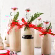 Sweet Irish cream bottles decorated for holiday season with red ribbons and greenery, perfect for festive gatherings.