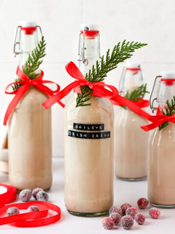 A few glass bottles filled with homemade Baileys with a ribbon.