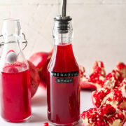 Side view of homemade grenadine in a bottle with label.