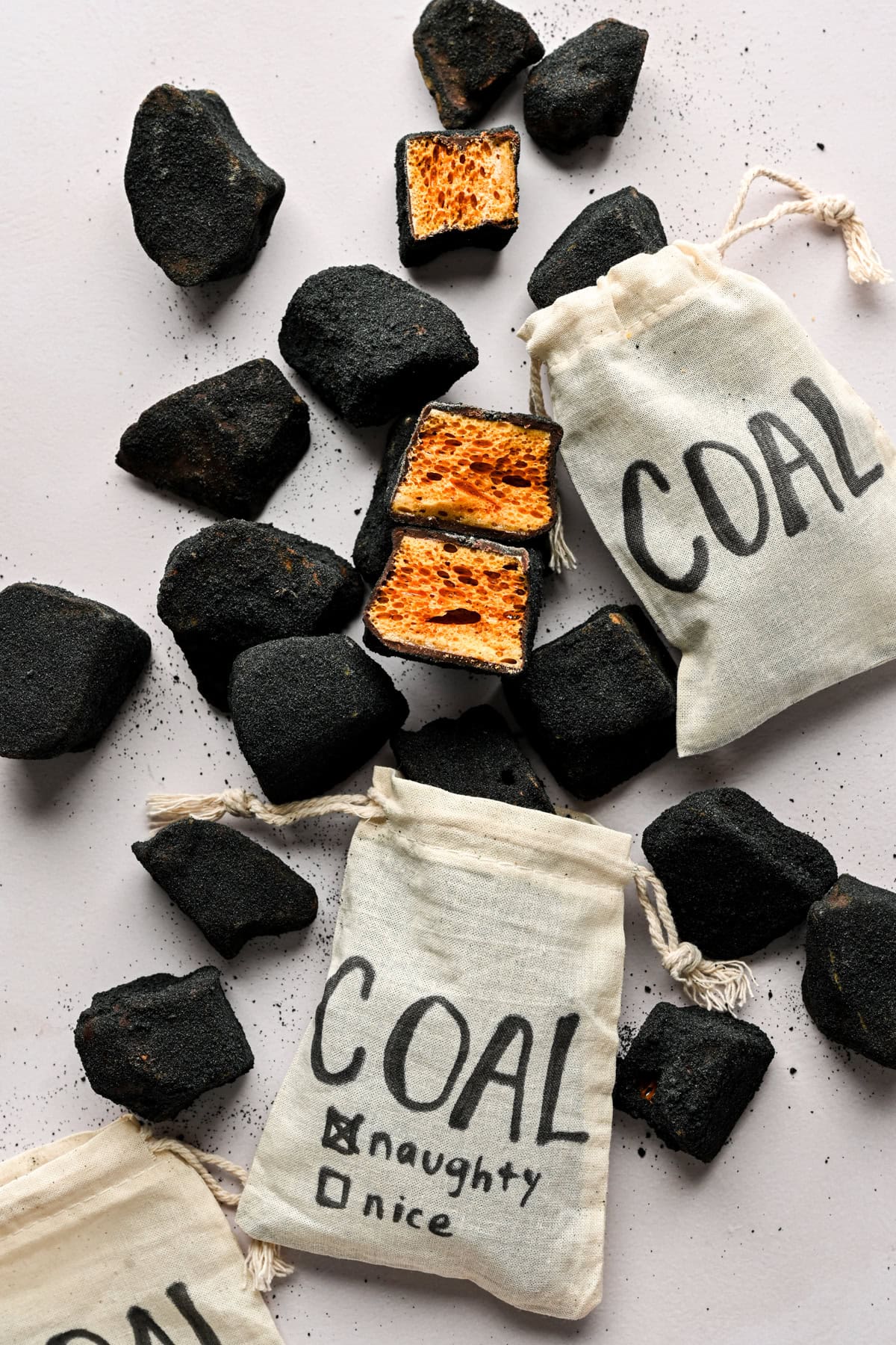 Overhead view of edible coal candy (chocolate covered honeycomb) with burlap bags full of coal.
