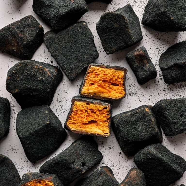 Filled honeycomb candy with black sesame coating, crunchy texture, popular treat in Asian desserts.
