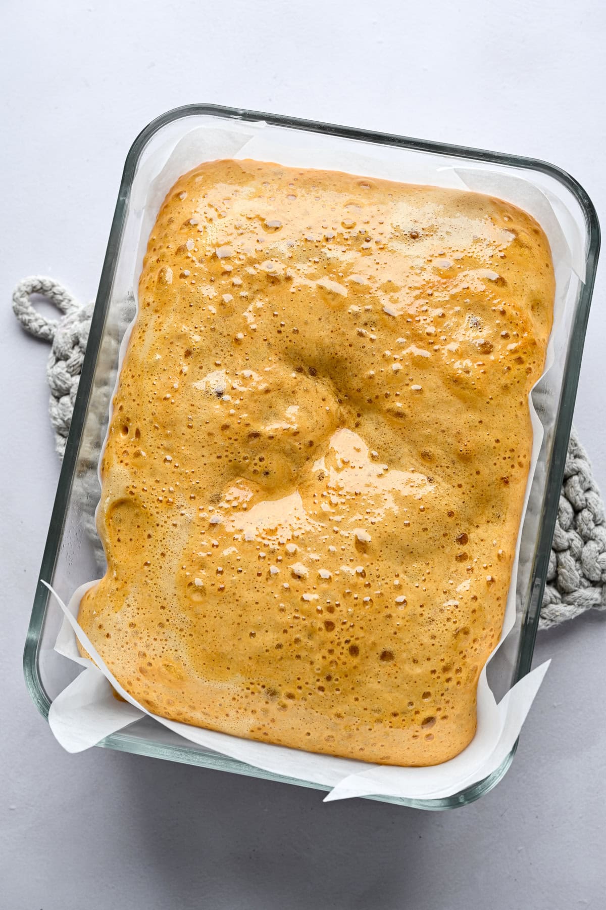 Honeycomb mixture in a pan lined with parchment paper.