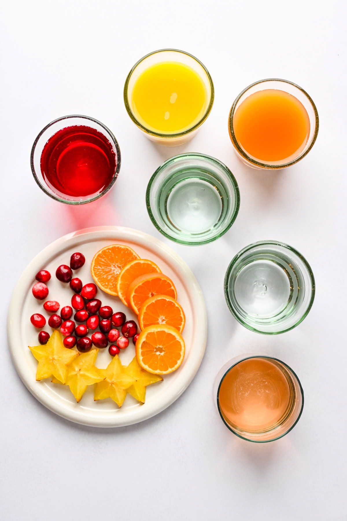 Overhead view of ingredients for jingle juice christmas punch in glasses. 