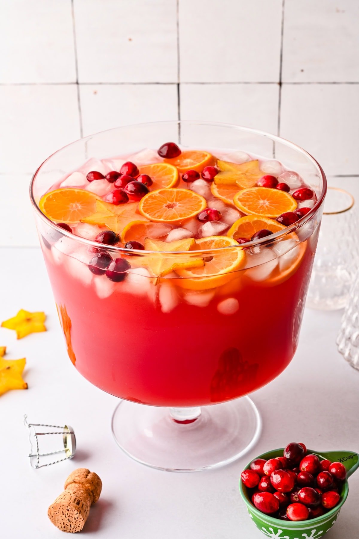 Side view of jingle juice christmas punch garnished with orange slices, cranberries and star fruit.