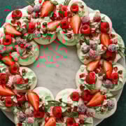 Freshly decorated cupcake wreath with mixed berries, mint frosting, and garnishes, perfect for summer desserts.