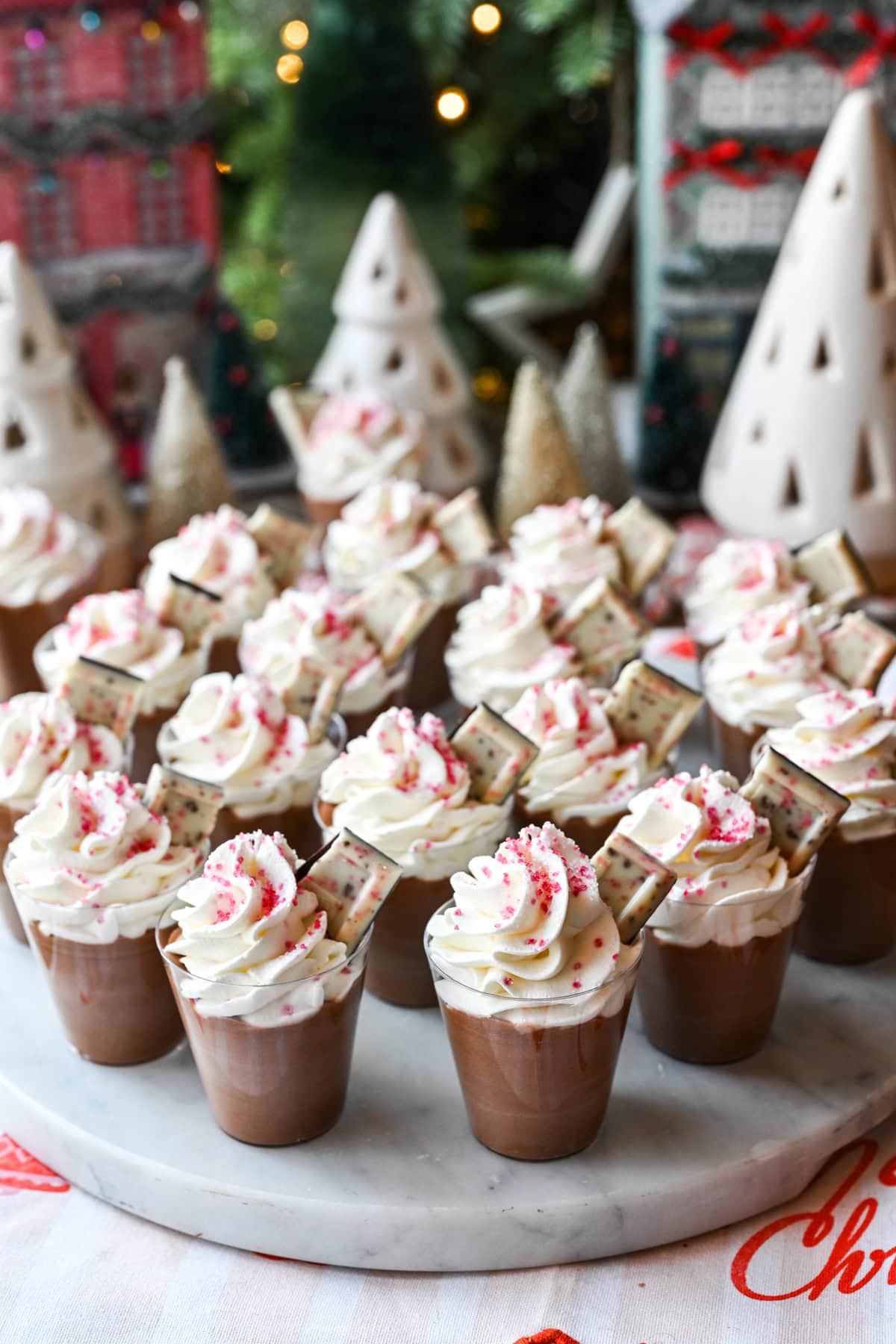 Peppermint Espresso martini pudding shots with whipped cream on a white marble serving tray. 